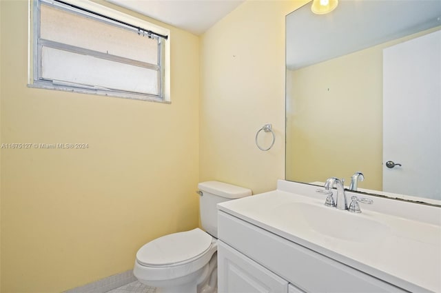 bathroom with tile patterned flooring, vanity, and toilet