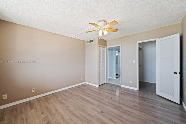 unfurnished bedroom featuring ceiling fan, a closet, and hardwood / wood-style flooring