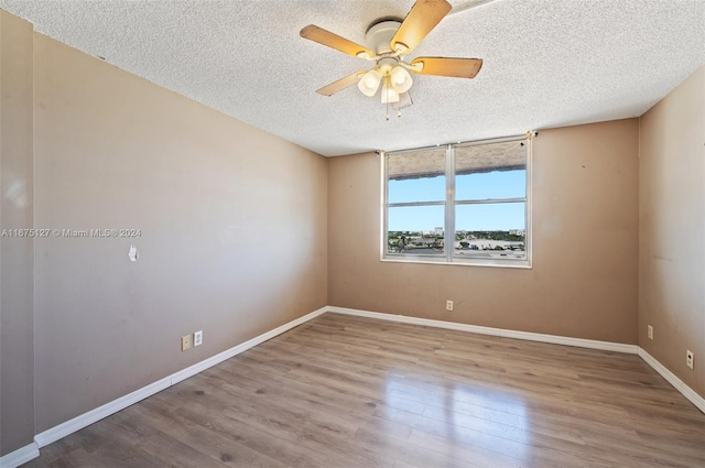 unfurnished room with wood-type flooring, a textured ceiling, and ceiling fan