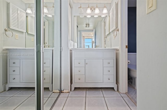 bathroom with tile patterned flooring, vanity, and toilet