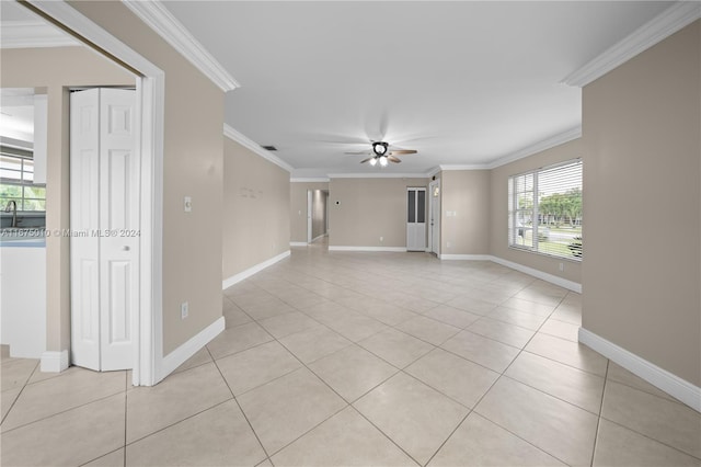 unfurnished living room with ceiling fan, light tile patterned floors, and ornamental molding