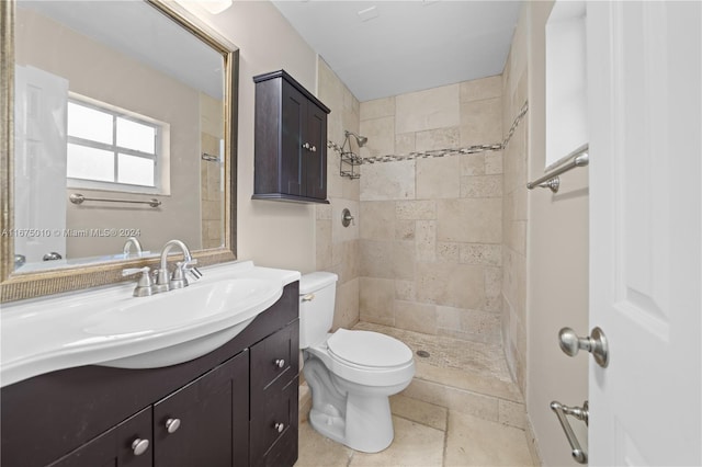 bathroom featuring vanity, toilet, and tiled shower