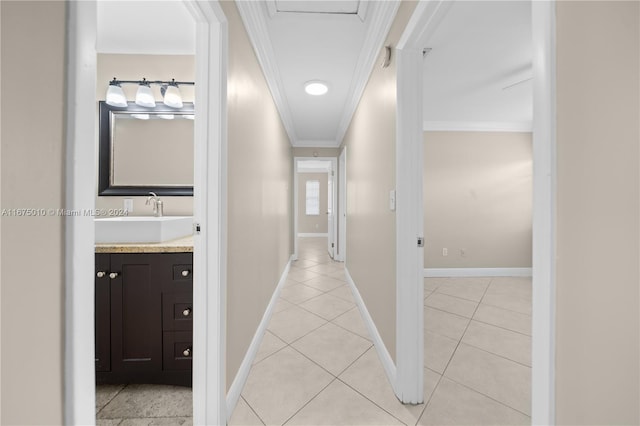 hallway with light tile patterned flooring, crown molding, and sink