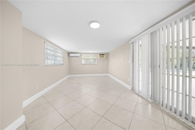 spare room featuring a wall mounted air conditioner and light tile patterned floors