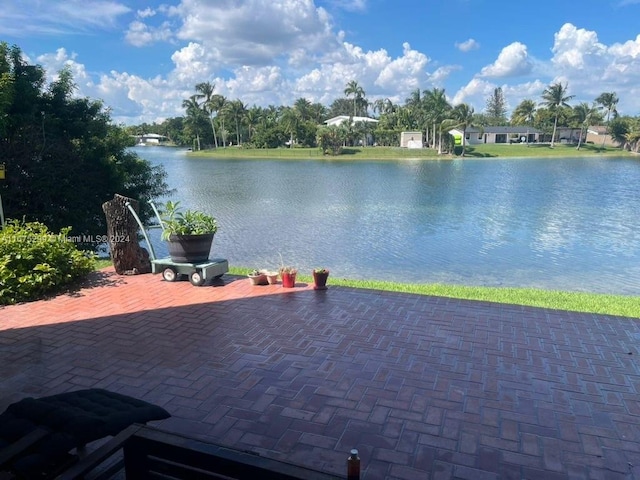 view of patio / terrace featuring a water view and ceiling fan