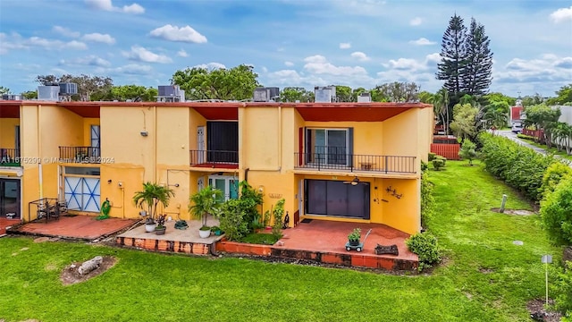 back of house featuring a patio area, a lawn, and a balcony