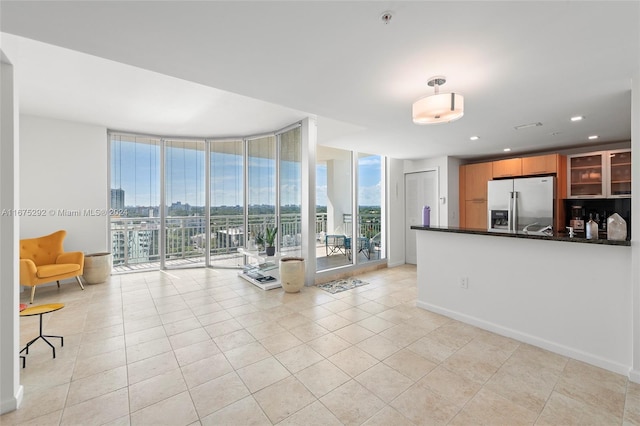 tiled living room featuring floor to ceiling windows