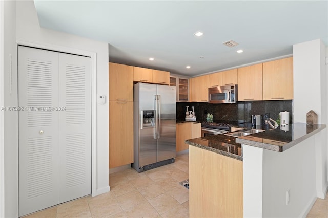 kitchen featuring light brown cabinets, sink, kitchen peninsula, tasteful backsplash, and appliances with stainless steel finishes