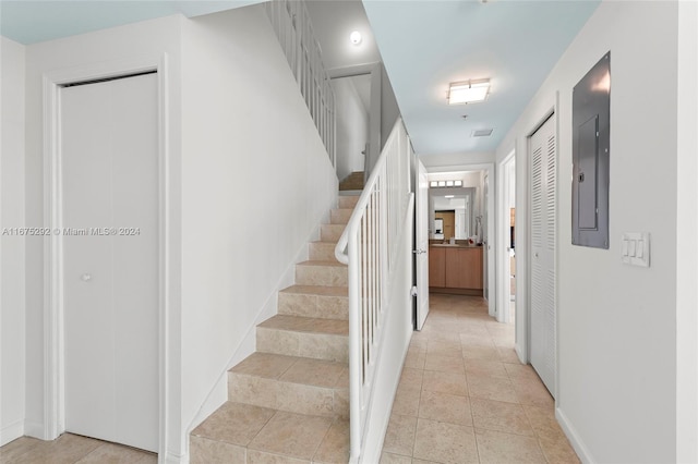 stairway with electric panel and tile patterned floors