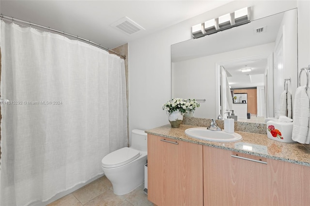 bathroom featuring vanity, tile patterned flooring, and toilet