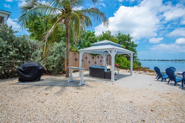 view of patio featuring a gazebo, an outdoor hangout area, grilling area, and a water view