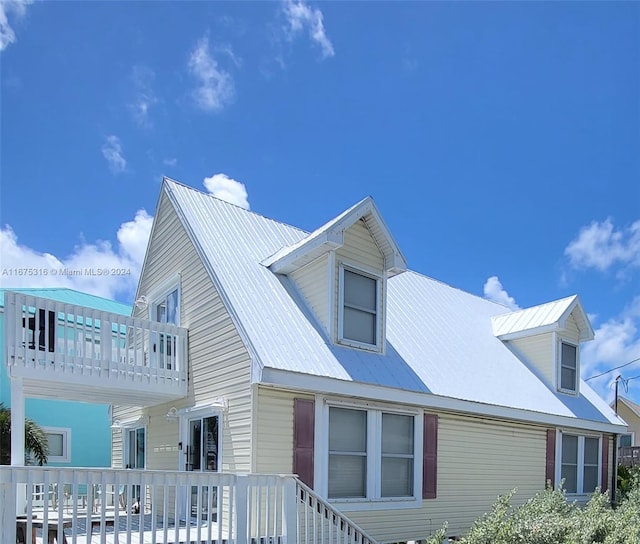 view of side of home featuring a wooden deck and a balcony