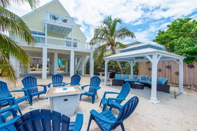 view of patio featuring a gazebo, an outdoor living space with a fire pit, and a balcony