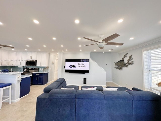 living room with crown molding, light tile patterned floors, and ceiling fan