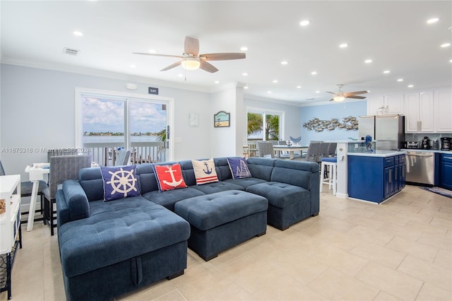 tiled living room with ceiling fan and ornamental molding