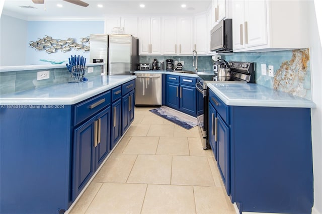 kitchen featuring tasteful backsplash, stainless steel appliances, white cabinets, blue cabinetry, and light tile patterned floors