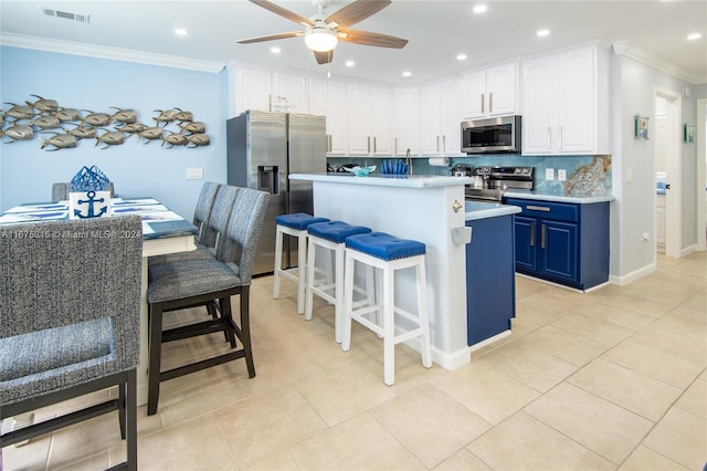 kitchen with blue cabinetry, backsplash, stainless steel appliances, crown molding, and a breakfast bar