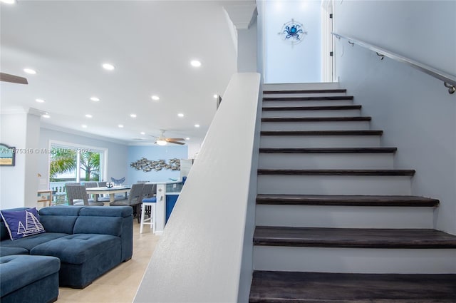 stairs featuring crown molding, wood-type flooring, and ceiling fan