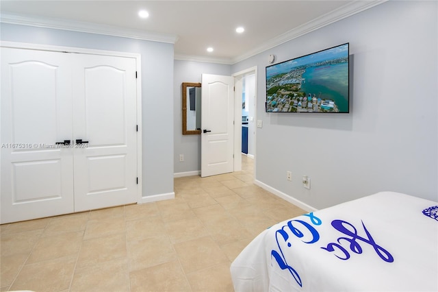 bedroom with a closet, ornamental molding, and light tile patterned flooring