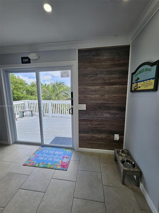 entryway with ornamental molding, a healthy amount of sunlight, and light tile patterned floors