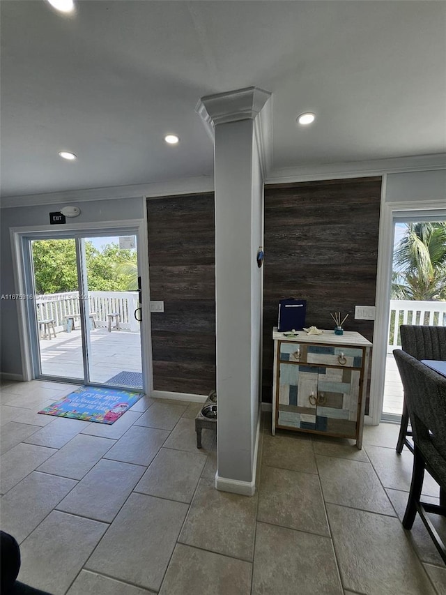 doorway featuring ornamental molding, a healthy amount of sunlight, and ornate columns