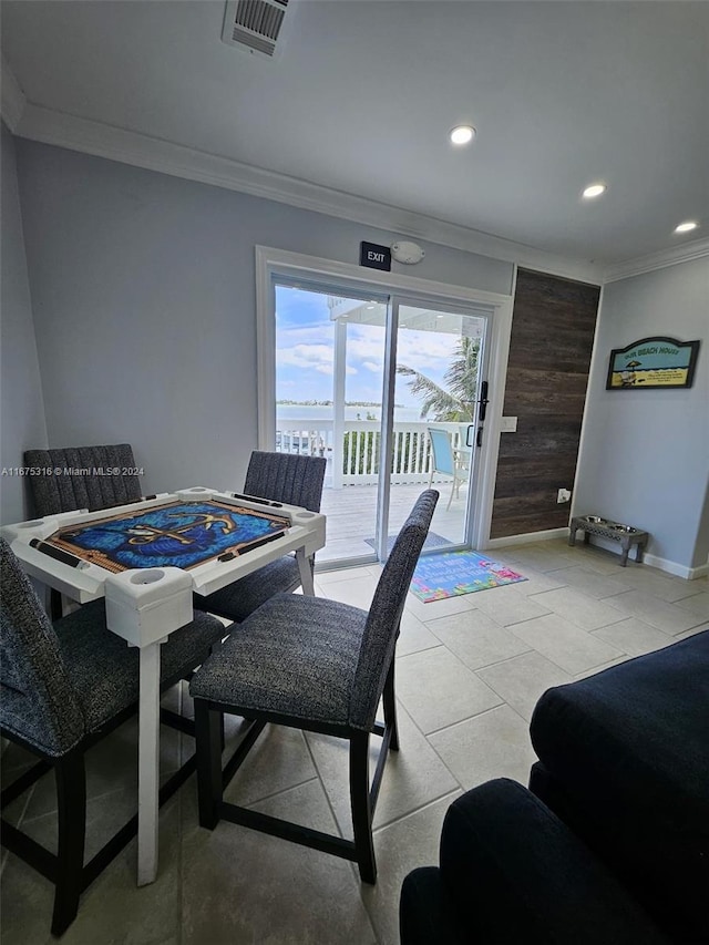 dining space featuring crown molding and light tile patterned floors