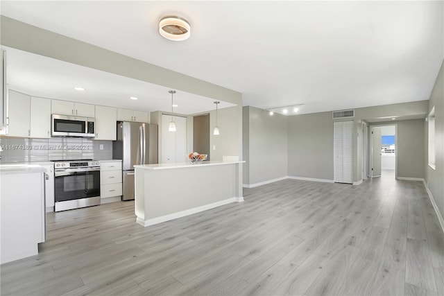 kitchen with decorative backsplash, appliances with stainless steel finishes, light wood-type flooring, decorative light fixtures, and white cabinetry