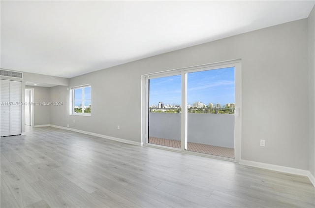 unfurnished room with light wood-type flooring and plenty of natural light