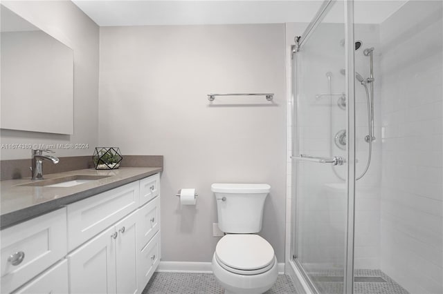 bathroom featuring vanity, toilet, a shower with shower door, and tile patterned flooring