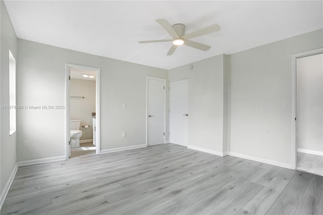 unfurnished bedroom featuring ensuite bath, baseboards, light wood-style floors, and a ceiling fan