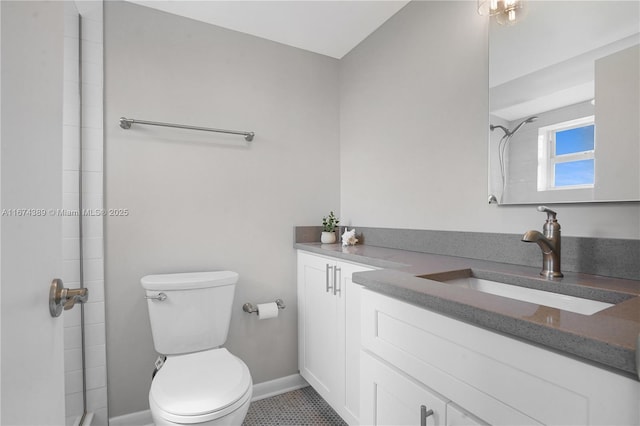 full bathroom with baseboards, vanity, toilet, and tiled shower