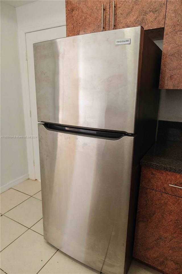 room details featuring light tile patterned floors and stainless steel fridge