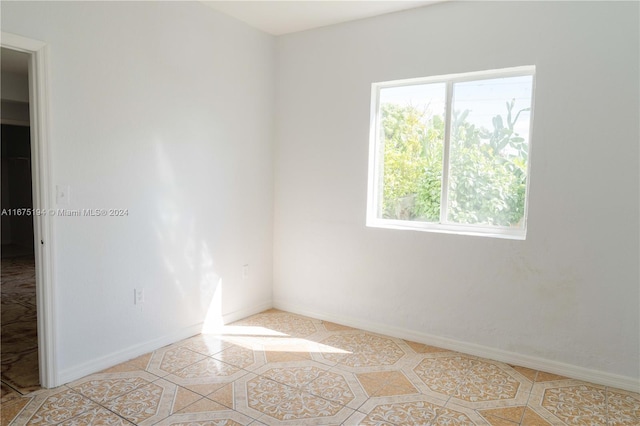 tiled spare room featuring a healthy amount of sunlight