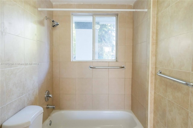 bathroom featuring toilet and tiled shower / bath