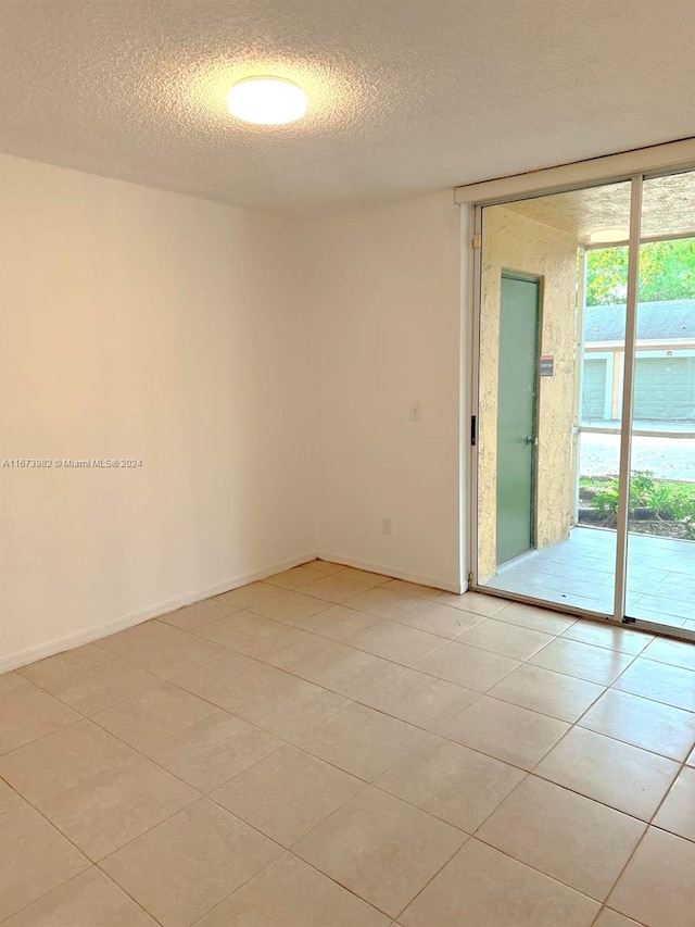 tiled spare room featuring a textured ceiling