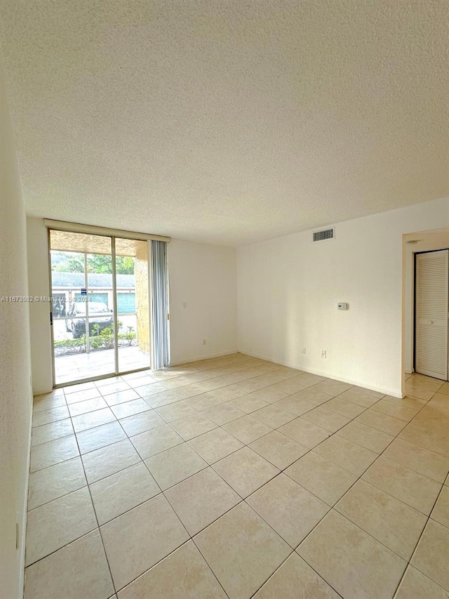 tiled spare room with a textured ceiling