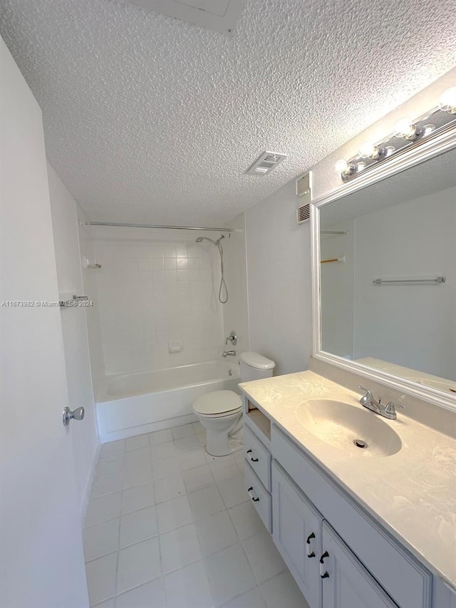 full bathroom with tiled shower / bath, vanity, toilet, and a textured ceiling