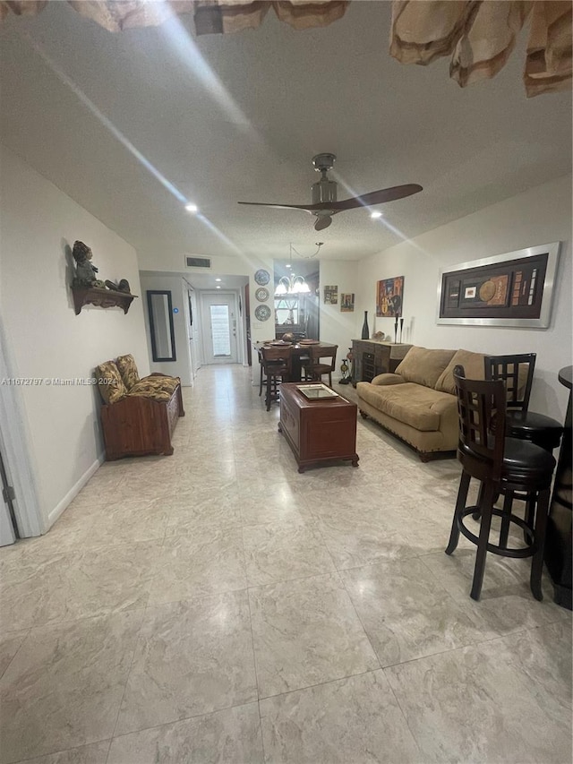 living room featuring vaulted ceiling, a textured ceiling, and ceiling fan