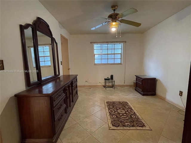 tiled empty room featuring ceiling fan