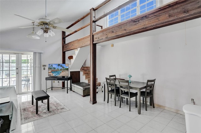 dining room with ceiling fan, light tile patterned floors, and high vaulted ceiling