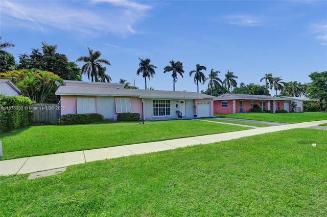 single story home featuring a front lawn and a garage