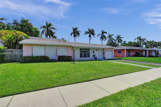 single story home featuring a garage and a front lawn