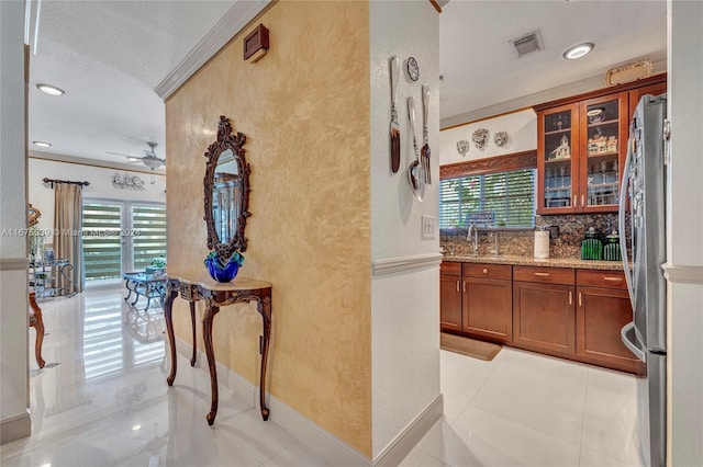 hallway with ornamental molding, sink, and a textured ceiling