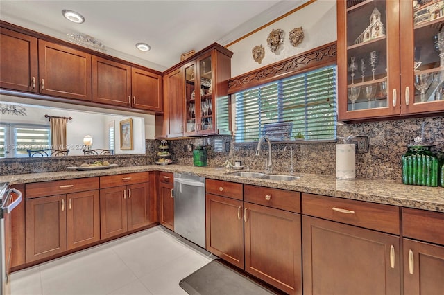 kitchen featuring light stone counters, sink, tasteful backsplash, and stainless steel dishwasher