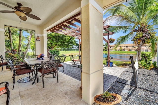 view of patio with a water view, a pergola, and ceiling fan