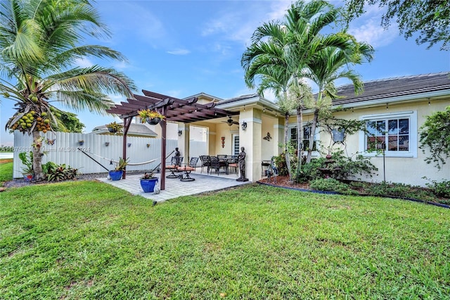 back of property with a yard, a pergola, and a patio area