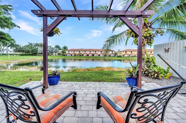 view of patio with a pergola and a water view