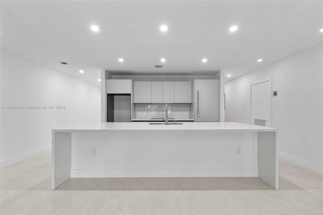 kitchen featuring white cabinets, sink, and a spacious island