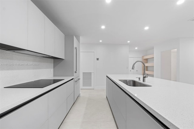 kitchen with sink, white cabinetry, and black electric stovetop