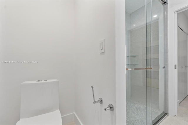 bathroom with a shower with shower door and toilet